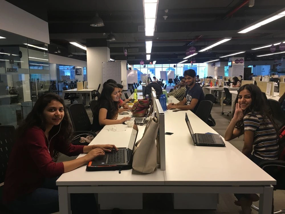 Colleagues working together around desks in a shared office