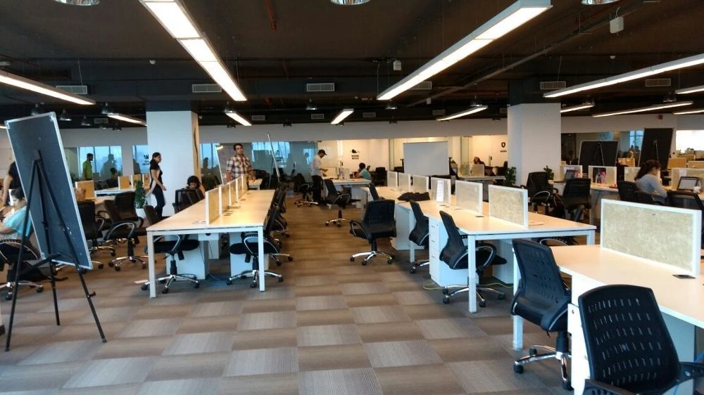 A wide view of a bright, open-plan workspace with desks and chairs